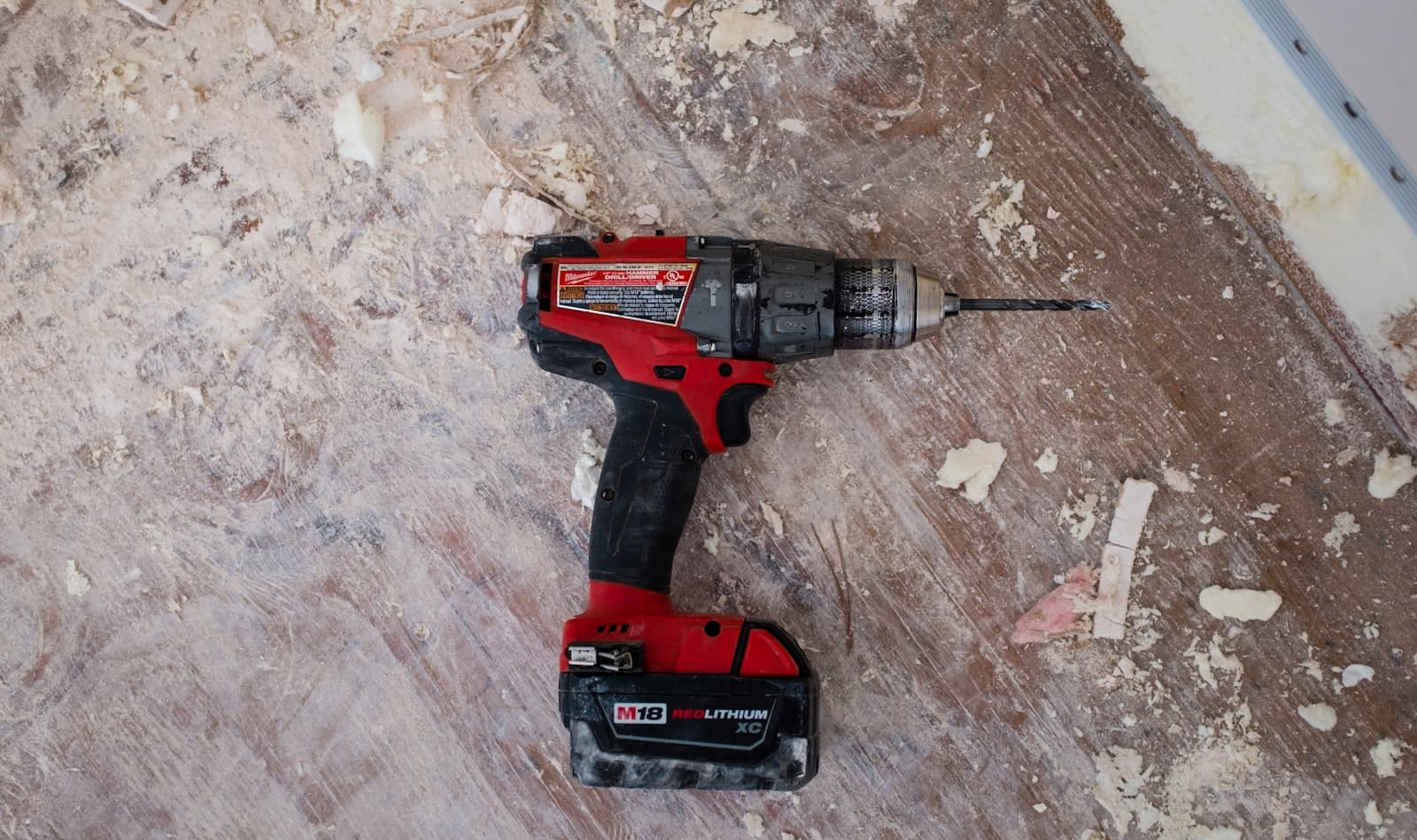 Cordless hammer drill on a dusty job-site floor