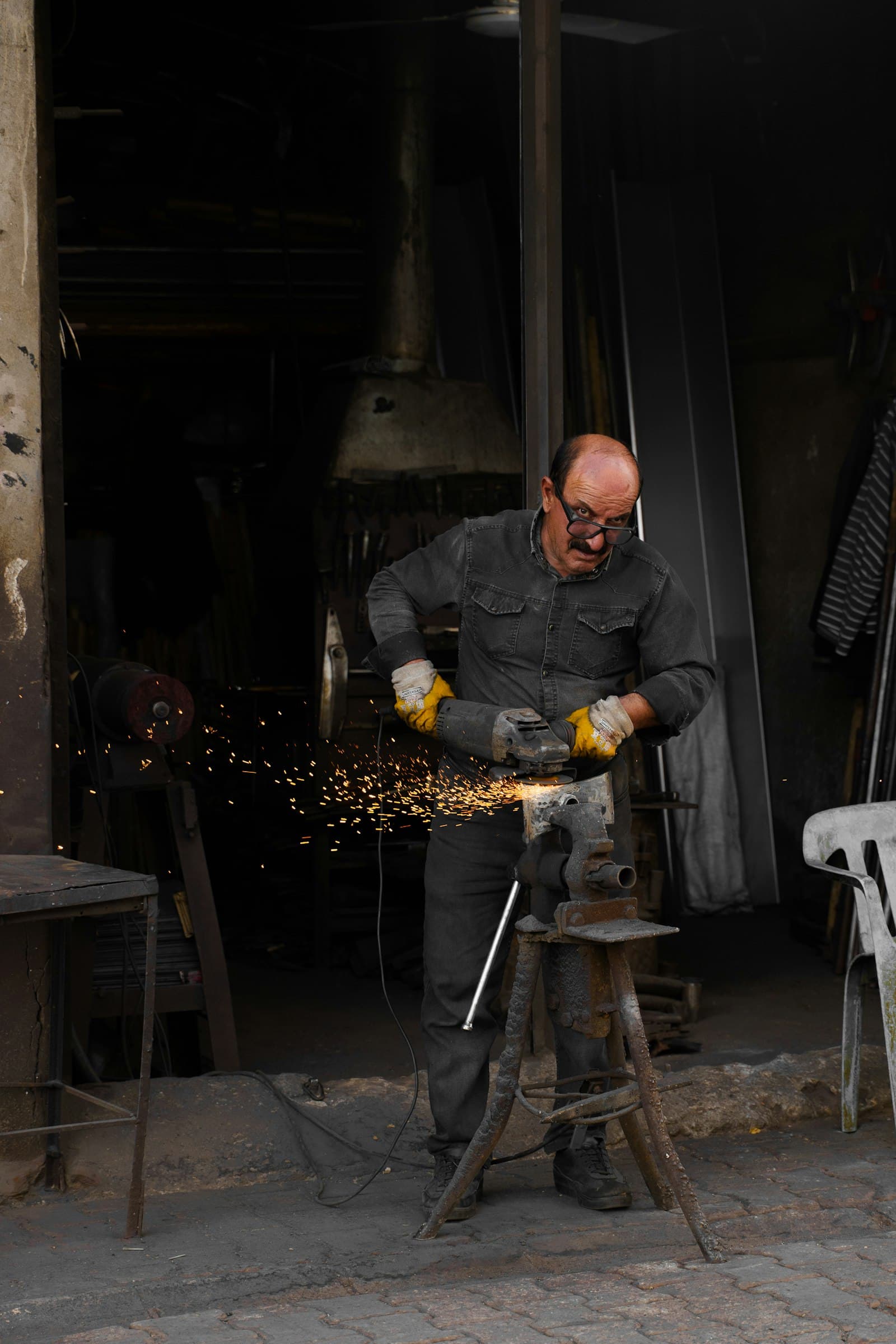 Metalworker grinding steel with an angle grinder in a workshop