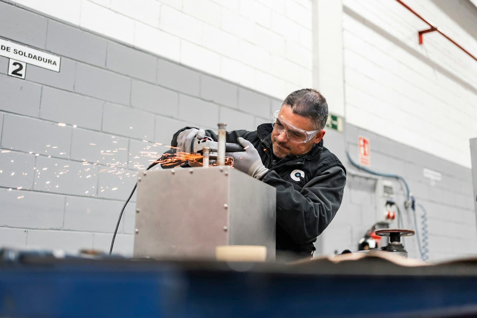 Fabricator using an angle grinder with a stream of sparks