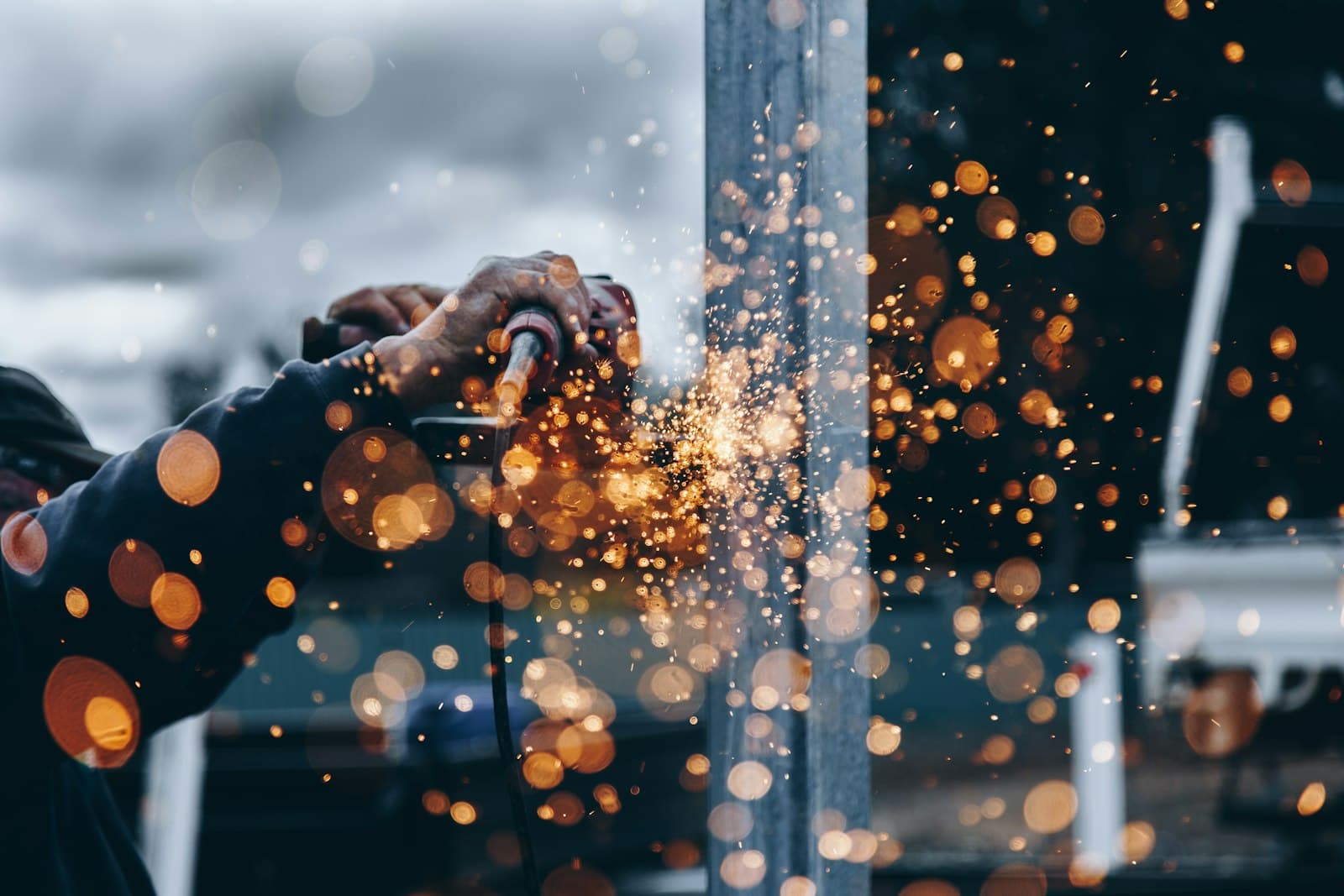 Angle grinder throwing sparks on a steel beam